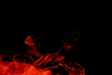 Fototapeta premium A cloud of red paint released into clear water. Isolate on a black background.