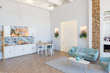Fashionable spacious apartment with a stylish design in green, grey and white pastel colors with big window and decorative walls. bedroom and kitchen space