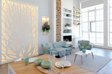 Fashionable spacious apartment with a stylish design in green, grey and white pastel colors with big window and decorative walls. bedroom and kitchen space