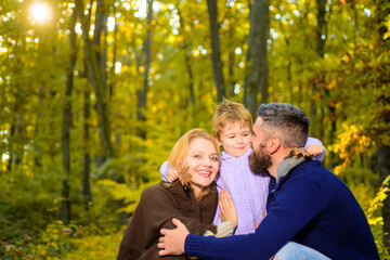 Happy family in autumn park. Autumn Family. Family parenthood and people concept - happy mother father and little boy in autumn park. Happy family together in yellow nature.