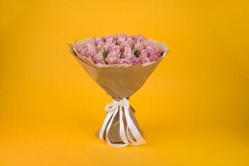 Beautiful bouquet of pink roses with on yellow background