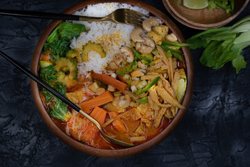 Vegan thai red curry with king oyster mushrooms, carrot, tofu, bokchoy, bitter gourd, cashew nuts. Jasmine rice. Copy space.