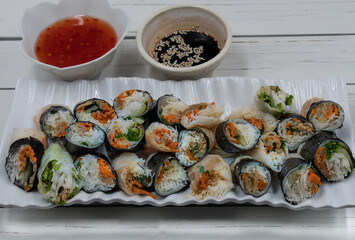 Vegan Vietnamese spring rolls on white platter, chili and soy sauce