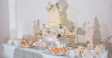Candy bar at the banquet. Wedding table with sweets, cake, pastries, muffins, sugar treats. Event in the restaurant
