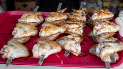 Fried chicken wings on skewers, selective focus.