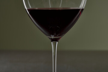 Rotwein im Glas auf dunklem Stein Tisch mit grünem Hintergrund