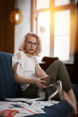 Stressed young woman looking angry, worrying about bank debt, looking away from her empty wallet, thinking of financial troubles. Lost in negative thoughts depressed angry woman.