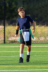 Fototapeta premium Young athletic boy playing in a flag football game