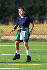 Obraz premium Young athletic boy playing in a flag football game