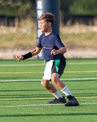 Young athletic boy playing in a flag football game