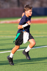 Obraz premium Young athletic boy playing in a flag football game