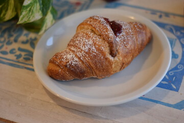 Un corazon de frambuesa dulce dentro de un croissant .