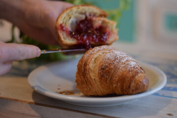 Un corazon de frambuesa dulce dentro de un croissant .