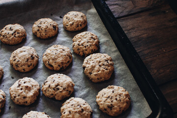 Freshly baked homemade oatmeal raisin cookies on wood background. Healthy snack. Flaxseed oatmeal cookies. Fresh out of the oven.