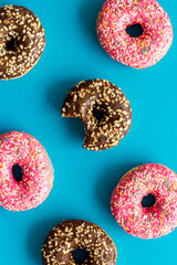 Donuts flat lay pattern on blue background, top view
