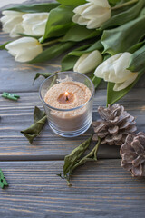 White tulips and candles on a blue wooden background. Top view with copy space.