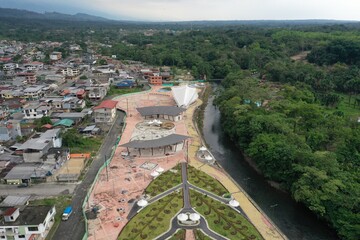 Fototapeta premium Aerial view of a small park at the edge of a small village next to the rainforest