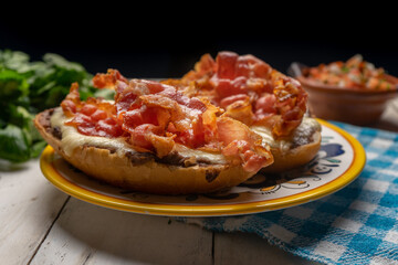 Mexican molletes with bacon and pico de gallo sauce on white background