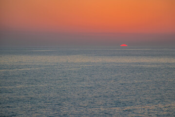 The orange sun sets over the horizon. Atlantic Ocean. Spain