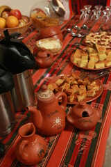 A buffet table with small snacks, coffee and tea and local handicrafts