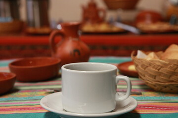 An white coffee cup on a table standing out against the colorful background