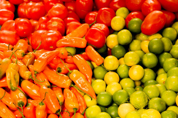 Colorful close up of lemons, tomatos and paprikas in green red and orange colors