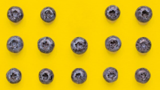 Macro shot blueberry appear and disappear on yellow background from adobe. Stop motion animation pattern. Food and vegetarian concept