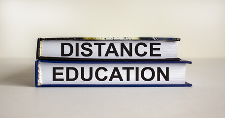 Books with text 'distance education' on beautiful white table. White background. Business concept. Copy space.