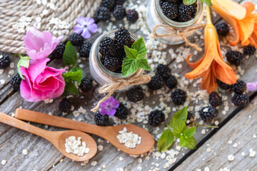 Fresh delicious yogurt for Breakfast with added blackberries. On fresh air. With flowers.