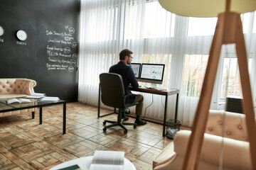 Concentrated businessman, financial analyst or sales manager working on computer in the modern...