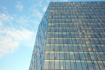 Glass facade of a modern multi-storey building against the sky