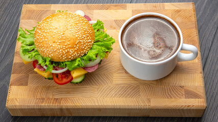 Hamburger with vegetables and sausage and coffee. Fast food and breakfast. Calories and diet.