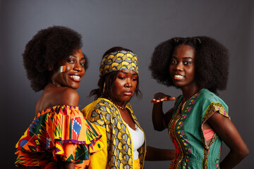 Three young beautiful African fashion models have fun and laughing in traditional dress. Women from the Congo Republic, Ivory Coast, and Zimbabwe