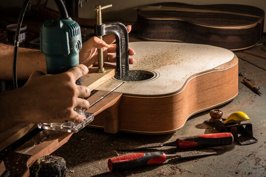 Luthier cutting a channel to place the truss rod in the guitar neck
