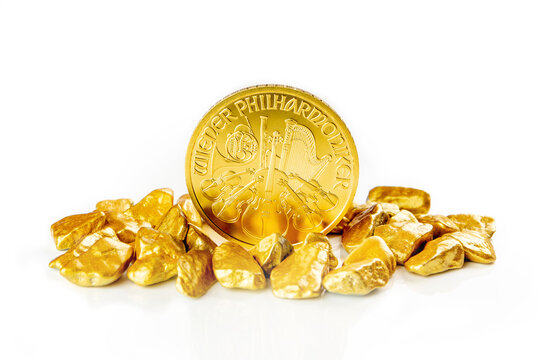 golden austrian philharmoniker one ounce coin laying on a heap of golden nuggets, golden ore