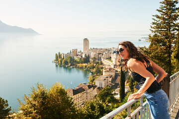 Fototapeta na wymiar Young beautiful woman tourist admiring amazing view of Montreux city, Switzerland, canton of Vaud