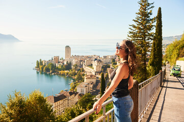 Young beautiful woman tourist admiring amazing view of Montreux city, Switzerland, canton of Vaud
