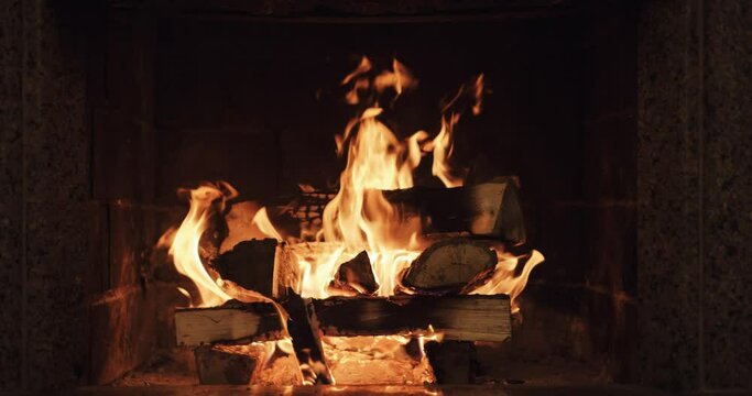 Slow motion of Fireplace burning. Warm cozy fire in a brick fireplace close up. Cozy winter relax background. Christmas mood. Filmed in RAW 120fps 4k DCi.