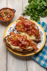 Mexican molletes with bacon and pico de gallo sauce on white background
