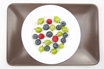 Assorted fresh different berries on a white plate. useful vitamin healthy food fruit. healthy vegetable breakfast