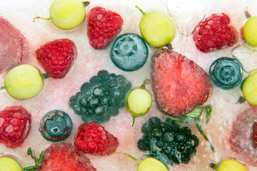 different juicy berries frozen in ice. useful vitamin healthy food