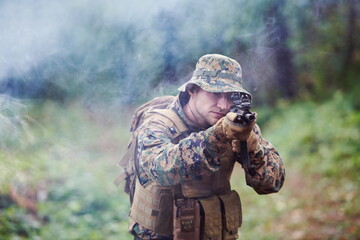 soldier in action aiming  on weapon  laser sight optics