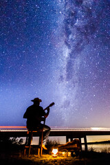 Musician playing under the Milky Way