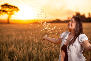 A girl on the oatmeal fields at sunset