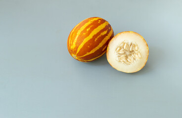 Vietnamese melon on a gray background. Miniature fruit with pineapple flavor. Close-ap. Copy space.