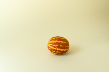 Small Vietnamese melon on a yellow background. Miniature fruit with pineapple flavor. Copy space. Horizontal orientation.