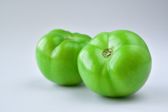 A Pair Of Unripe Green Tomatoes Isolated On White