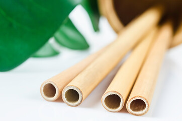 Close up bamboo straws with green leaf.