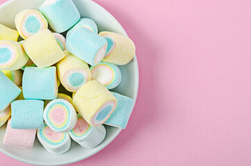 Colorful marshmallows in white dish.