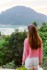 Young girl admiring beautiful view of Phi Phi Don island. View from the back.